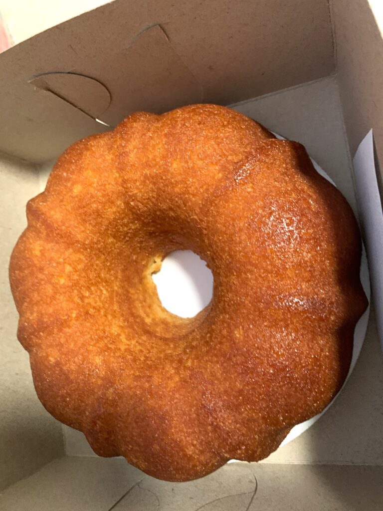 A whole Black Cherry Bourbon Cake from Chez Moi Bakery in a cake box.