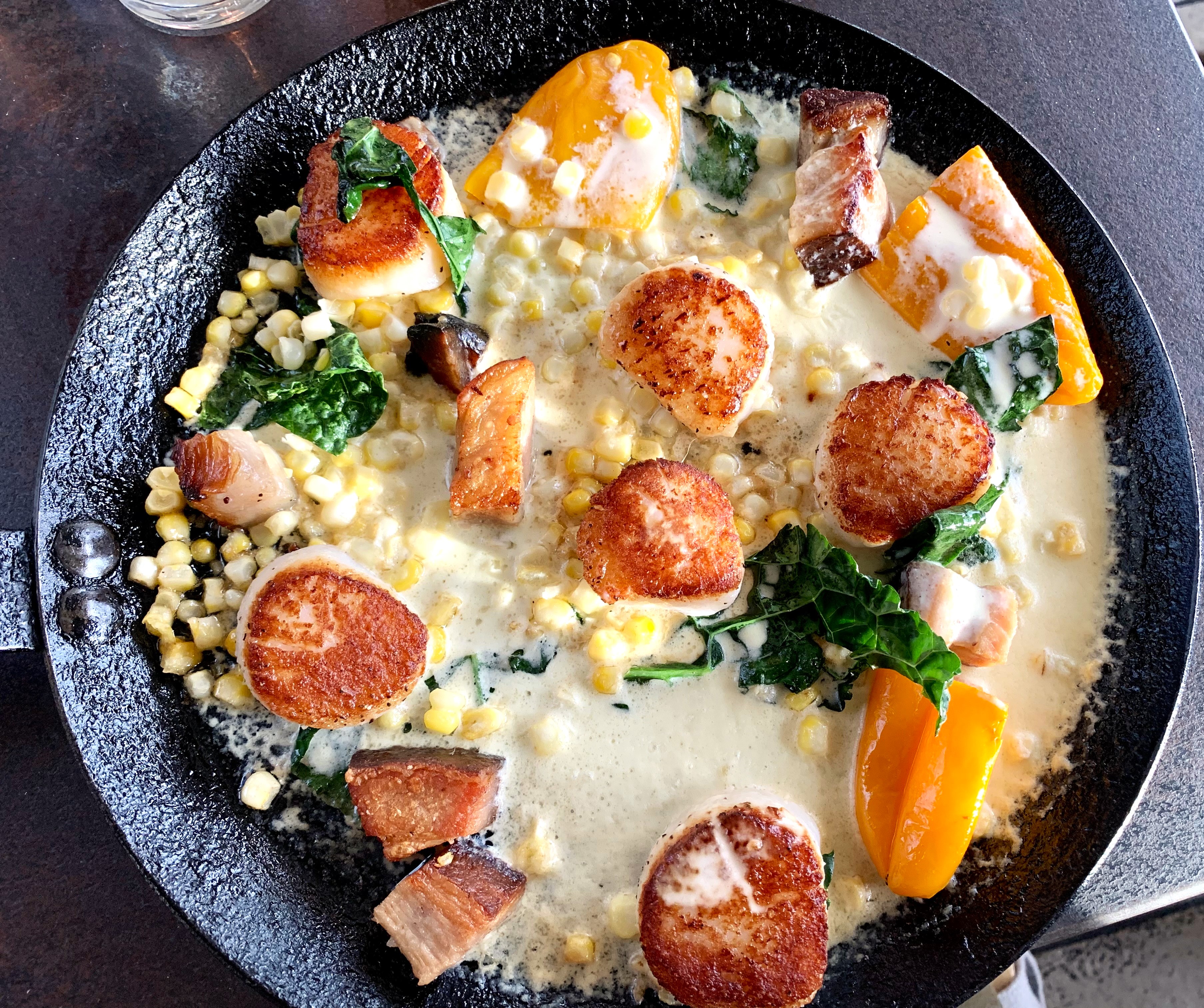 Seared Scallops in a creamy corn sauce with peppers and pork belly.