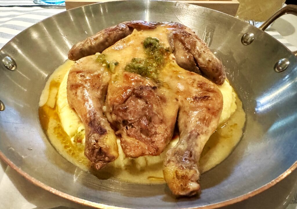 A silver platter with a roasted baby chicken atop pureed potatoes., Milano Cafe, Port Hercules, Monaco